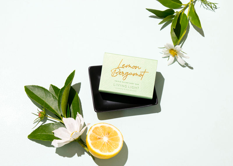 Lemon bergamot body bar in soap tray with lemon flowers surrounding bar | Living Light