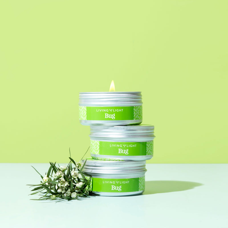 Soy and essential oil travel candle in silver twist tin with green label and a green background. 
